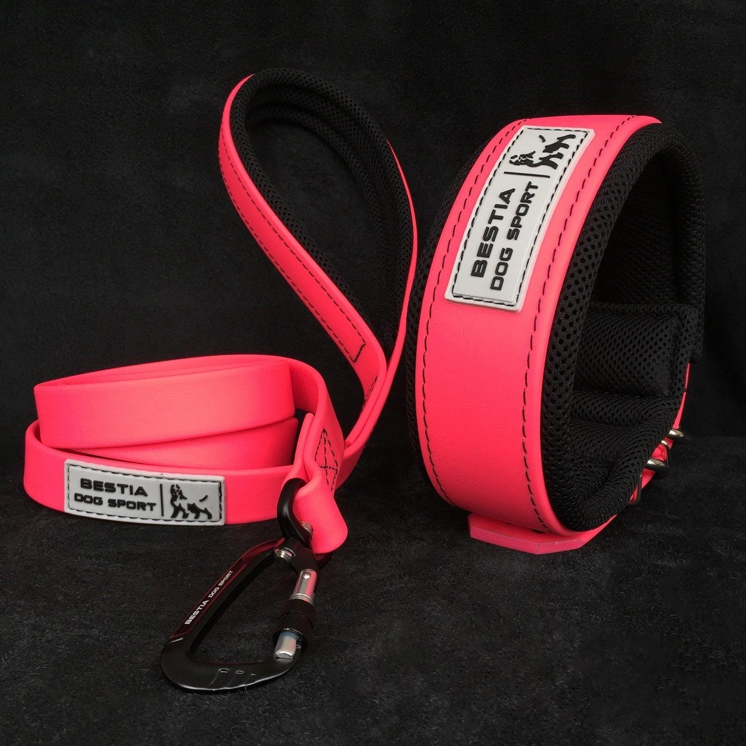 Die BESTIA DOG SPORT – Taktische Leine Neon Pink, eine neonpinke Hundeleine mit gepolstertem schwarzen Futter und „Bestia Dog Sport“-Aufschrift, ist auf schwarzem Hintergrund abgebildet.
