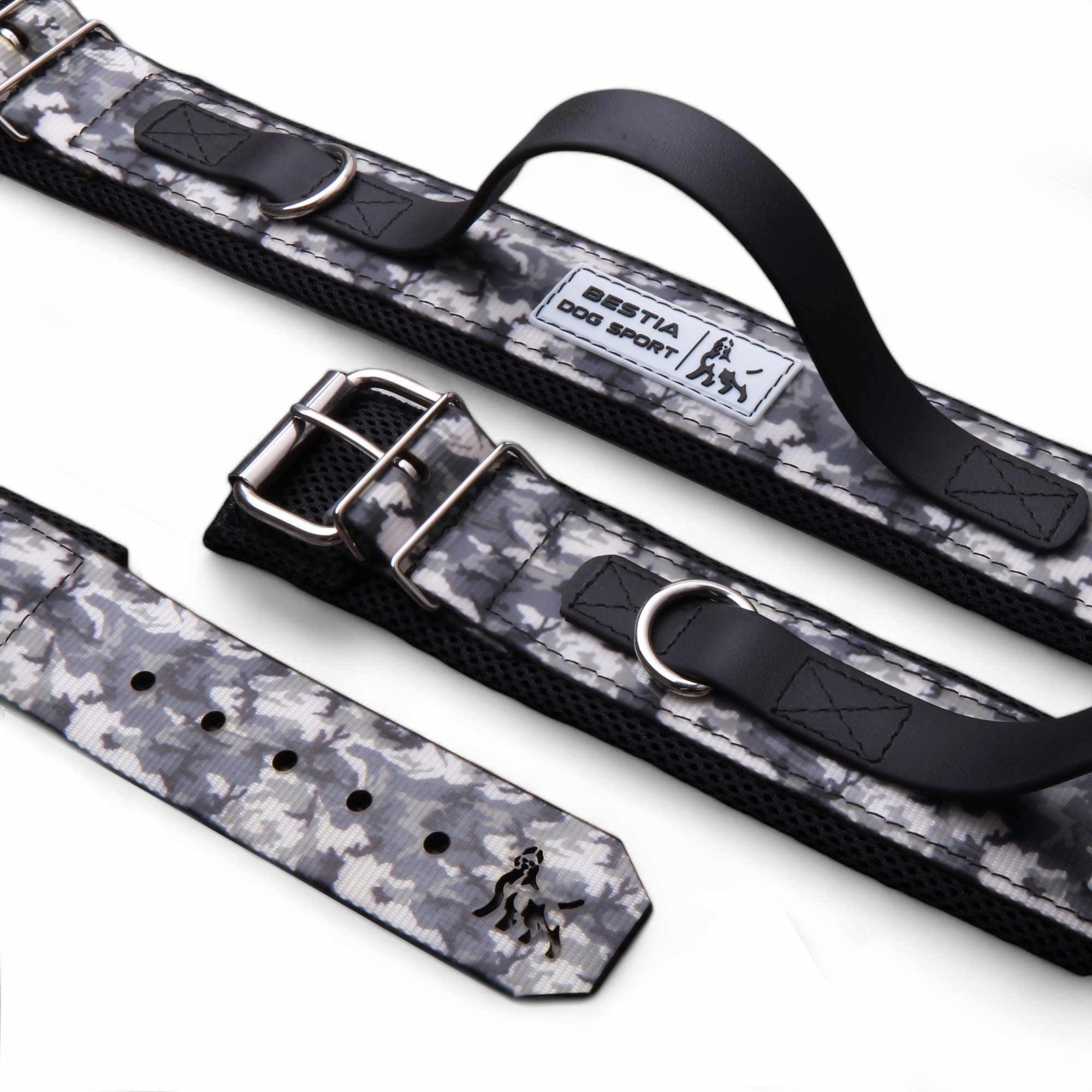 Das BESTIA DOG SPORT – Handle Halsband Grey Camo von BESTIA DOG SPORT verfügt über einen stabilen Griff, D-Ringe aus Metall, eine sichere Schnalle und ein Logo-Etikett auf weißem Hintergrund.