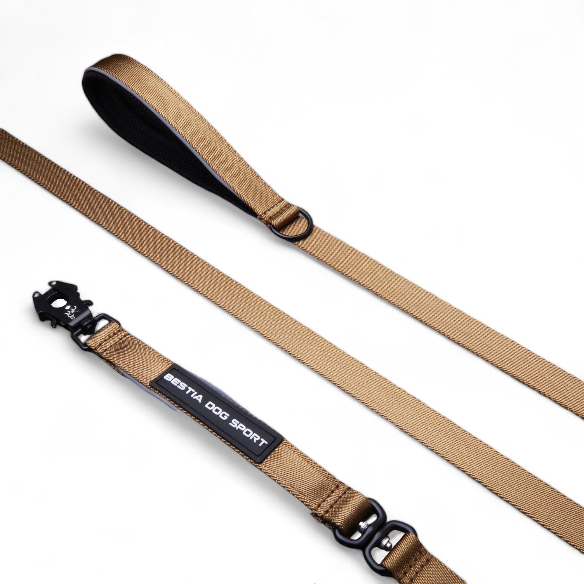 Eine hellbraune BESTIA DOG SPORT – GripPro Leine aus strapazierfähigem Nylon mit gepolstertem Griff, stabilem Metallclip und BESTIA DOG SPORT-Label ist auf weißem Hintergrund abgebildet.