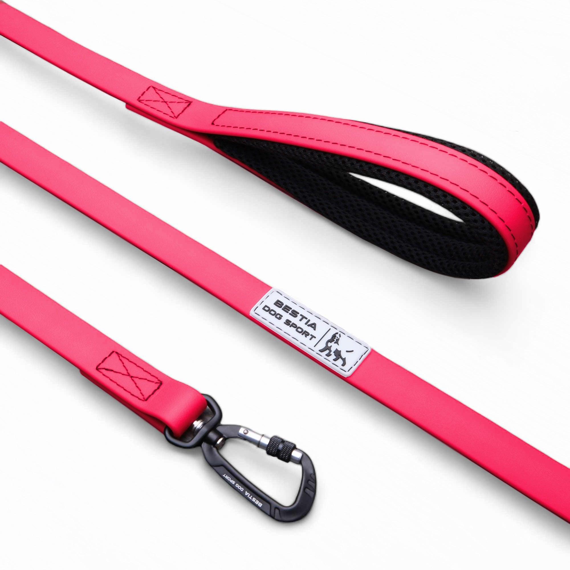 Die BESTIA DOG SPORT – Taktische Leine Neon Pink verfügt über ein neonpinkes Design, einen schwarz gepolsterten Griff, einen Metallclip und ein „BESTIA DOG SPORT“-Etikett auf weißem Hintergrund.