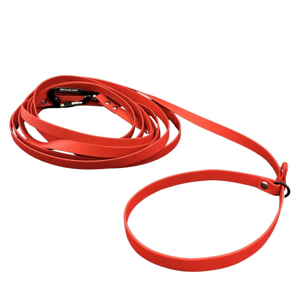 Die BESTIA DOG SPORT – Multifunktions-Schleppleine 5 m ist eine gewickelte rote Hundetrainingsleine mit einem Aluminiumkarabiner und einem Schlaufengriff, perfekt für das Hundetraining, abgebildet auf weißem Hintergrund.