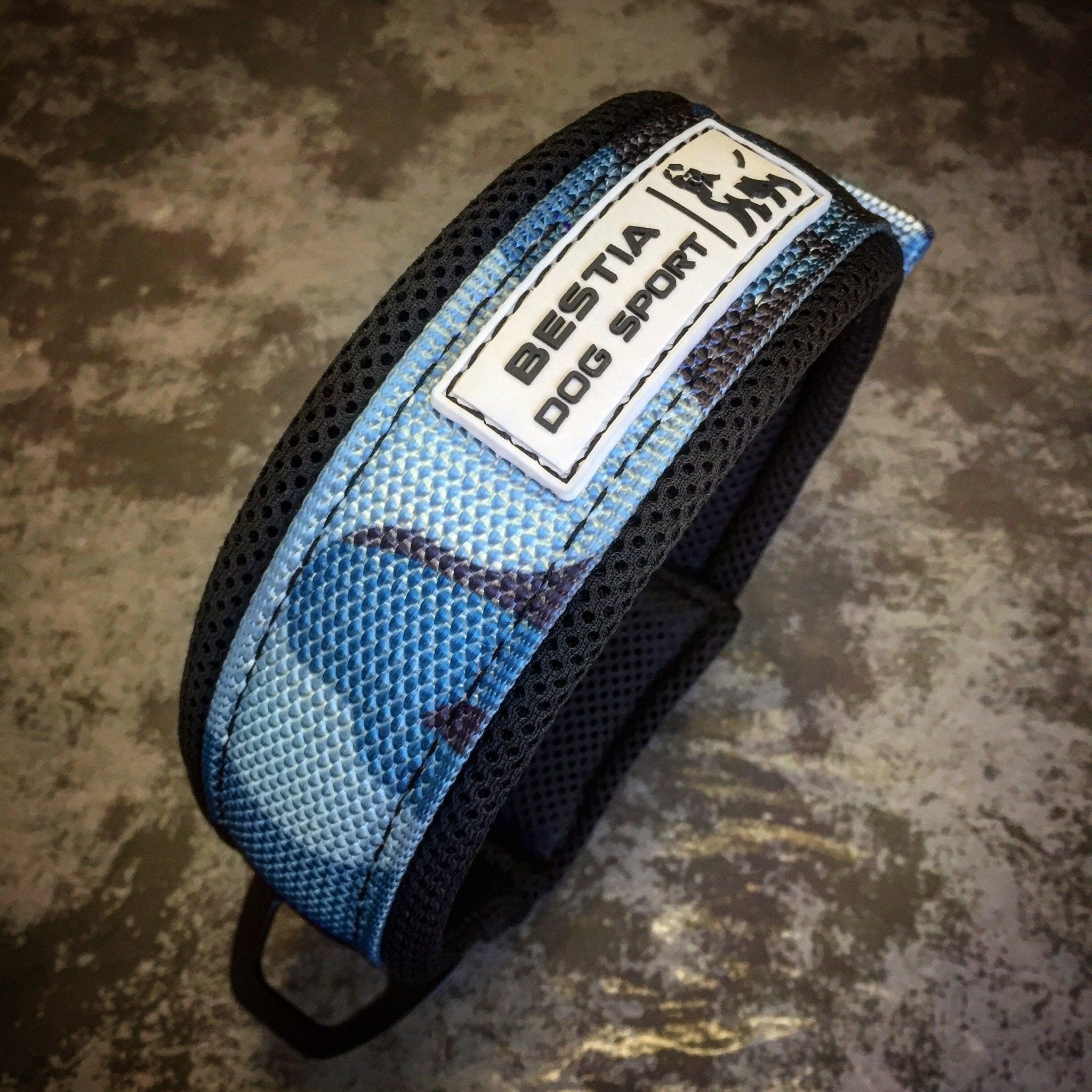 Ein BESTIA DOG SPORT – Schnellverschluss-Halsband in Blue Camo ist auf einer strukturierten grauen Oberfläche abgebildet.