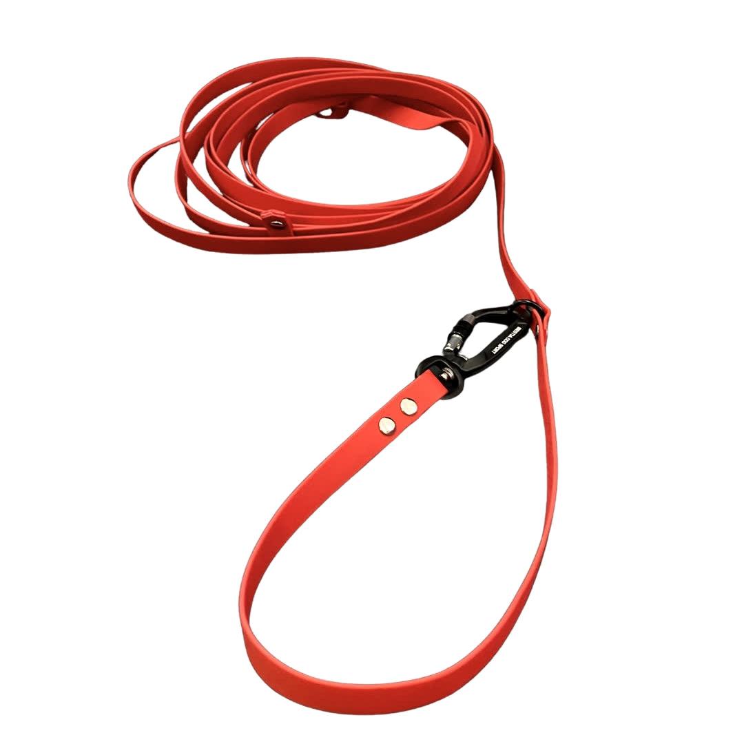 Die aufgerollte Bestia Dog Sport – Multifunktions-Schleppleine 5m von BESTIA DOG SPORT in Rot mit Aluminium-Karabiner und silbernen Nieten ist auf weißem Hintergrund zu sehen – perfekt fürs Hundetraining.